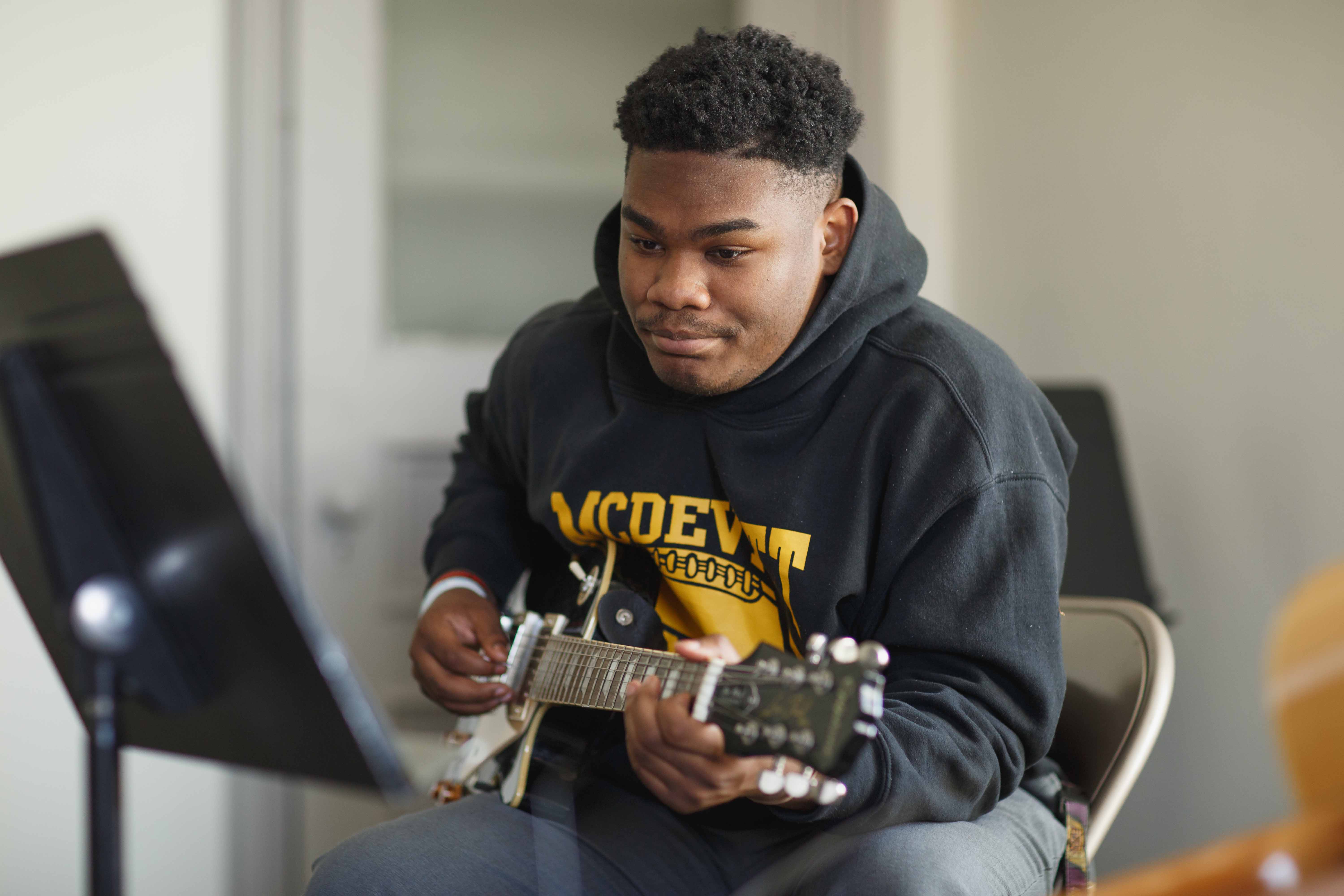 child with a smile holding a guitar